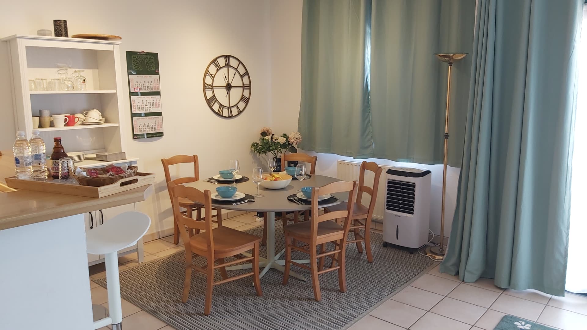 Salle à manger de l'appartement meublé Bruyères Lodge à Louvain-la-Neuve, avec table dressée et cuisine équipée
