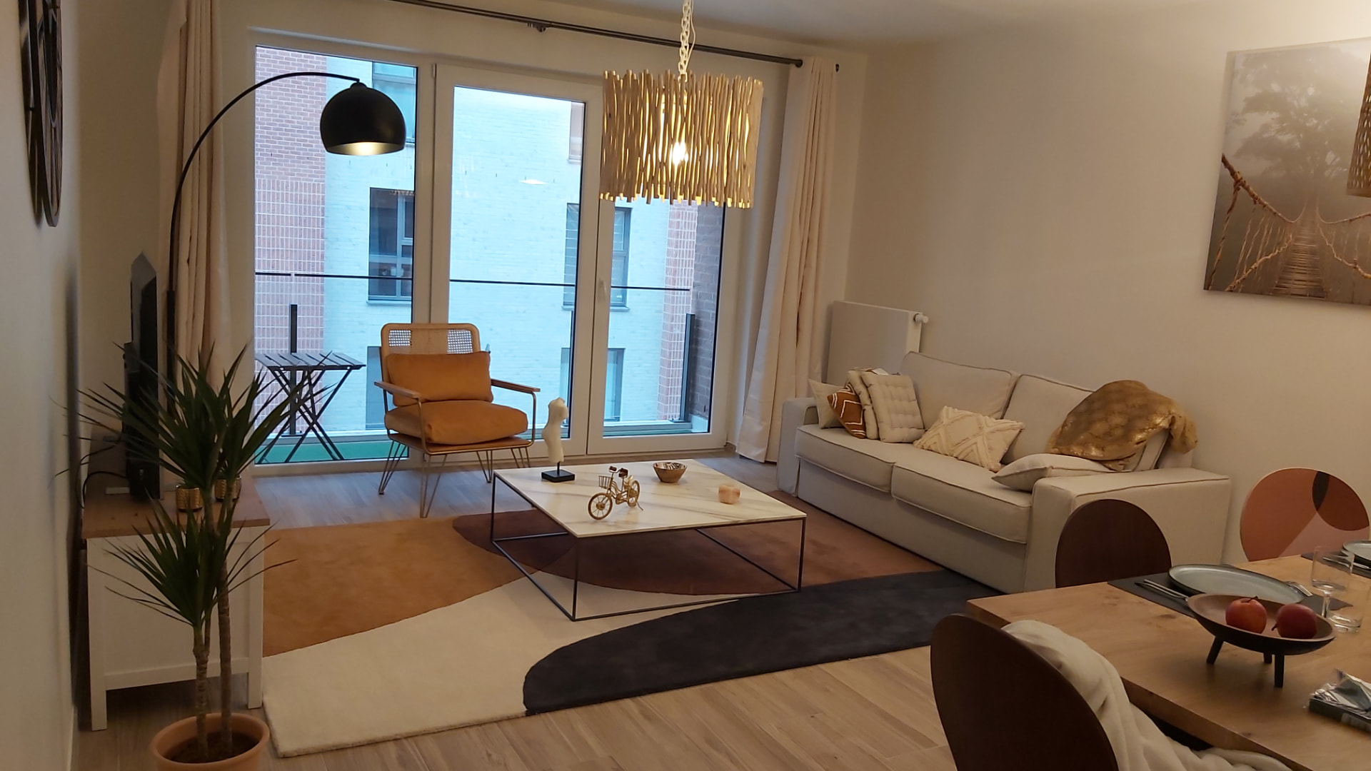 Salon de l'appartement meublé Courbevoie Lodge à Louvain-la-Neuve, avec canapé beige et fauteuil ocre